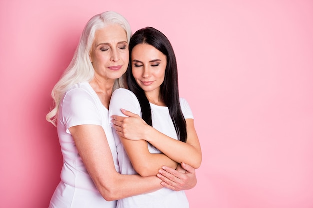 moeder en dochter knuffelen geïsoleerd op roze