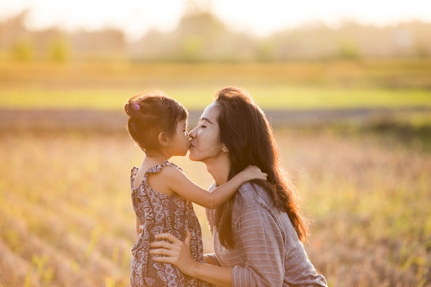 Moeder en dochter kussen in het veld