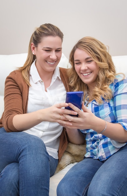 Moeder en dochter lachen als ze naar de telefoon kijken