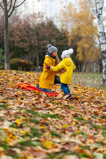 Moeder en dochter lezen een boek in het park Herfstplek voor tekst