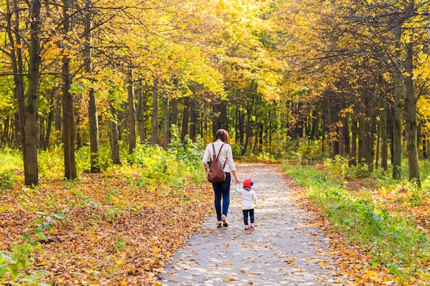 Moeder en dochter lopen in het herfstpark