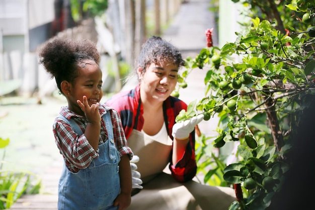 Moeder en dochter maken buitenactiviteiten in de tuin divers familie gelukkig moederschapsweekend samen met kind moederdag concept