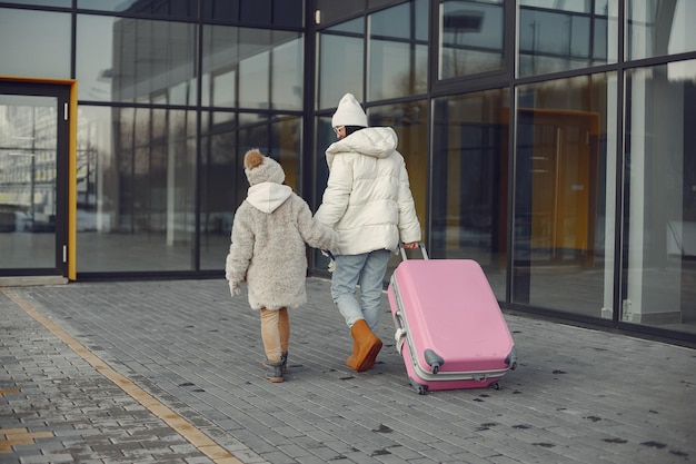 Moeder en dochter met bagage naar luchthaventerminal