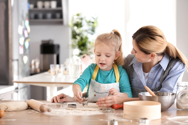 Moeder en dochter met deeg aan tafel binnenshuis