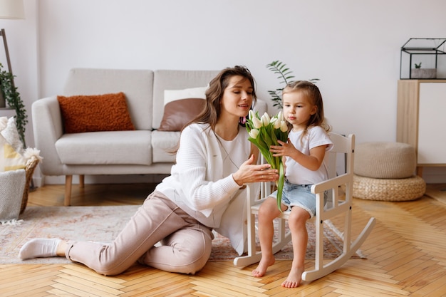 Moeder en dochter met een boeket tulpen komen thuis in de lente