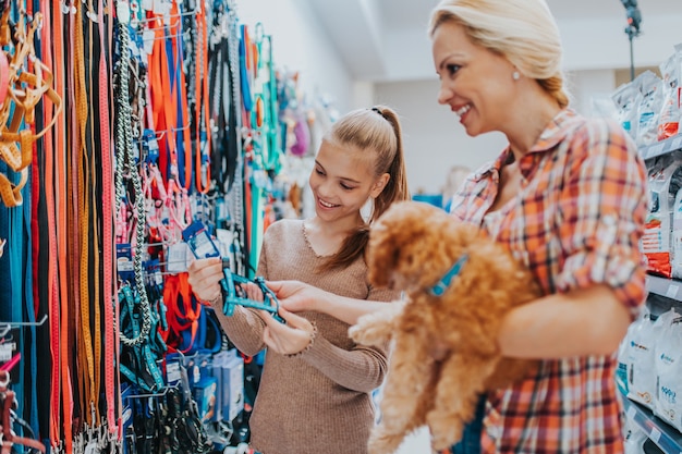 Moeder en dochter met hun poedelpuppy in dierenwinkel.