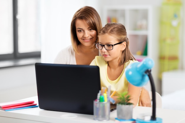 moeder en dochter met laptop die huiswerk doen