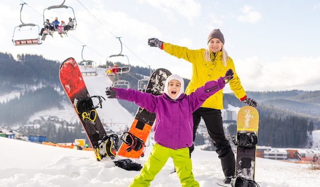 moeder en dochter met snowboards in winterresort