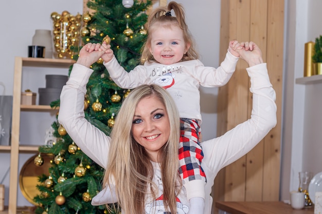 Moeder en dochter naast de kerstboom. nieuwjaar en kerstmis vakantie. mooie moeder en dochter.