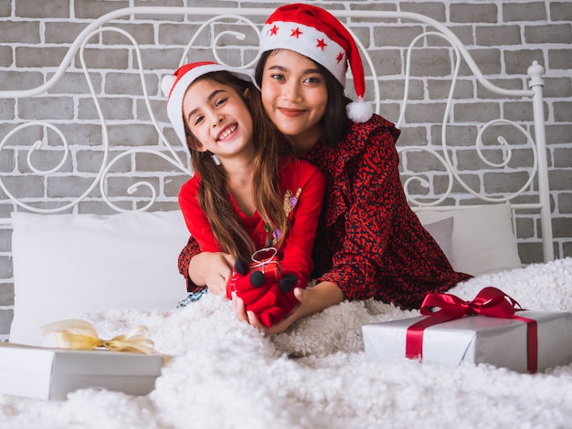 Foto moeder en dochter omhelzen elkaar gelukkig en vieren kerstmis op bed