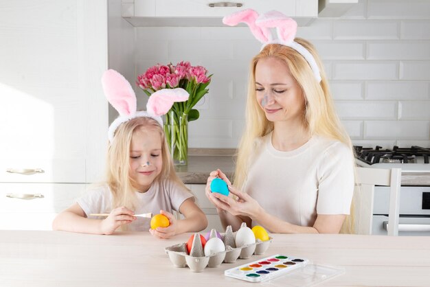 Moeder en dochter schilderen eieren voor Pasen