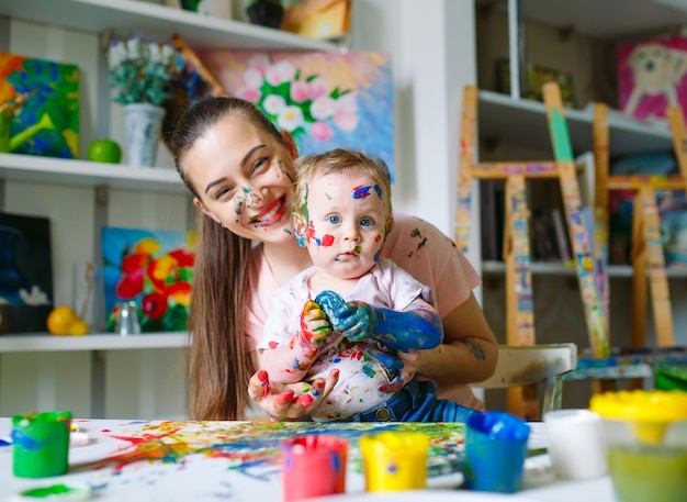 Moeder en dochter schilderen op canvas op de tekenschool.