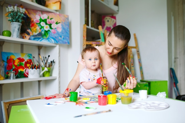 Moeder en dochter schilderen op canvas op de tekenschool.