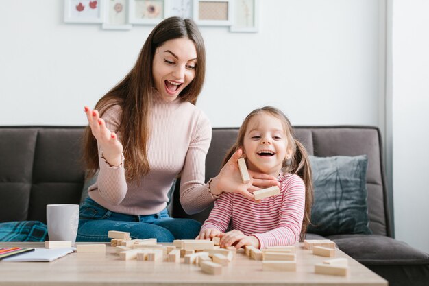 Moeder en dochter spelen een bordspel in de woonkamer.