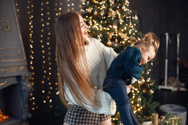 Moeder en dochter spelen en veel plezier bij de kerstboom