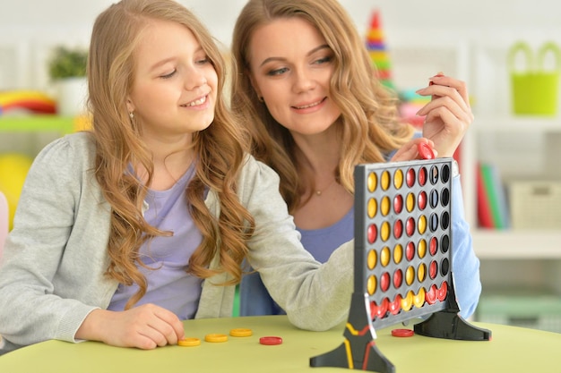 Moeder en dochter spelen samen terwijl ze in de kamer zitten