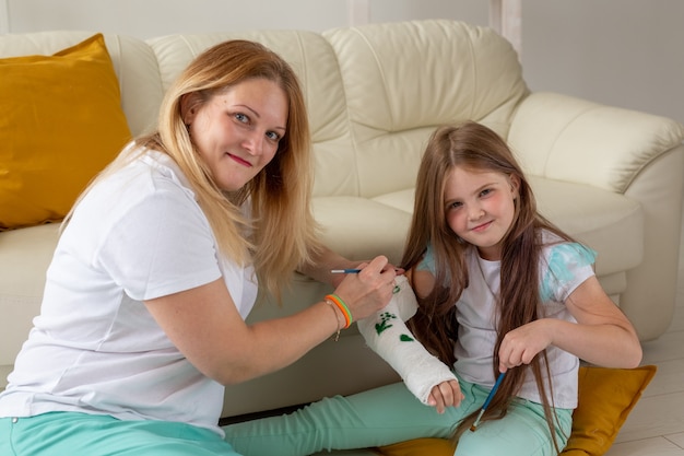 Moeder en dochter tekenen foto op verband met behulp van verven speltherapie concept