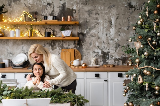 Moeder en dochter voor kerstboom.