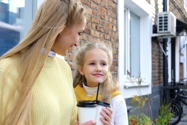 Moeder en dochter zitten buiten en drinken warme chocolademelk terwijl ze het weekend samen doorbrengen