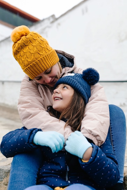 Moeder en dochter zitten en kijken elkaar met liefde aan