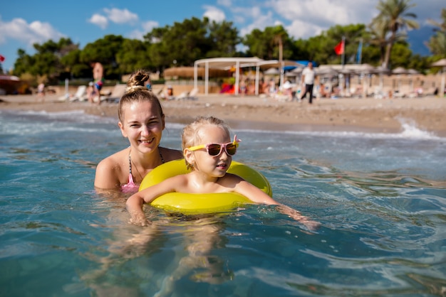 Moeder en dochtertje baden in de zee.