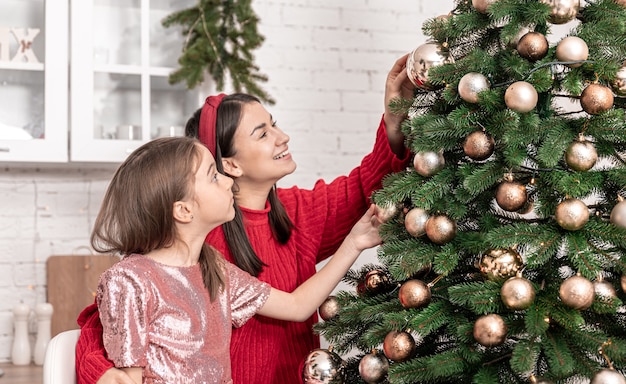 Moeder en dochtertje versieren samen de kerstboom