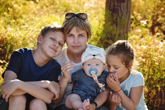 Moeder en drie kinderen in de zomertijd