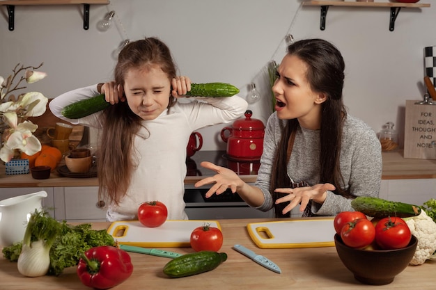 Moeder en haar dochter maken een groentesalade en hebben plezier in de keuken.