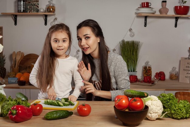 Moeder en haar dochter maken een groentesalade en hebben plezier in de keuken.