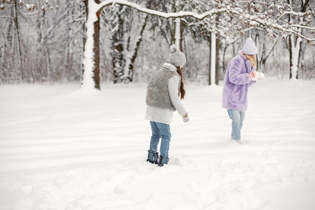 Moeder en haar dochter spelen in sneeuwballen in de winter