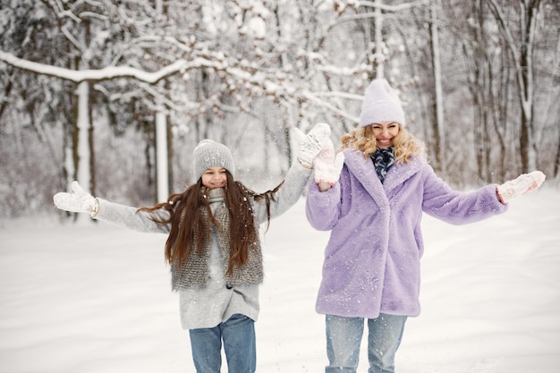 Moeder en haar dochter spelen in sneeuwballen in de winter