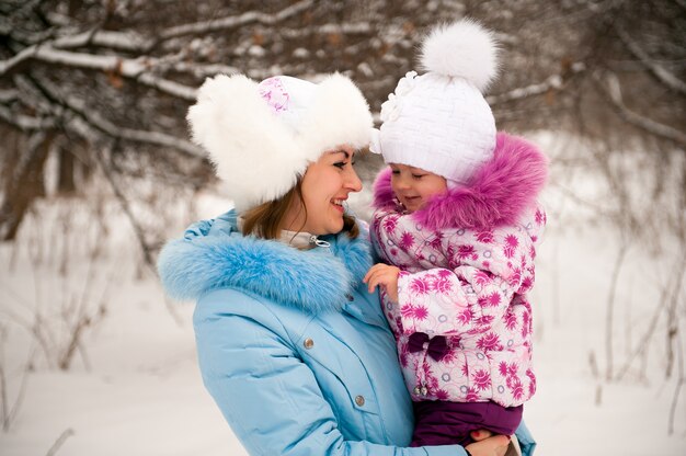 Moeder en haar dochtertje genieten van mooie winterdag buiten.