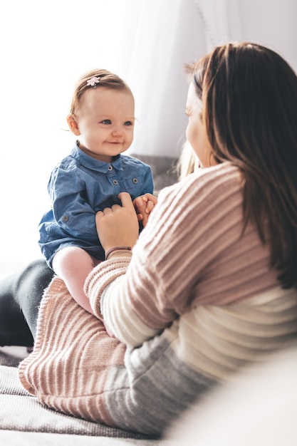 Moeder en haar dochtertje hebben plezier op de bank thuis Gelukkige familie