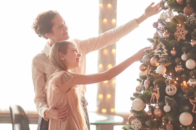 Moeder en haar dochtertje versieren de kerstboom