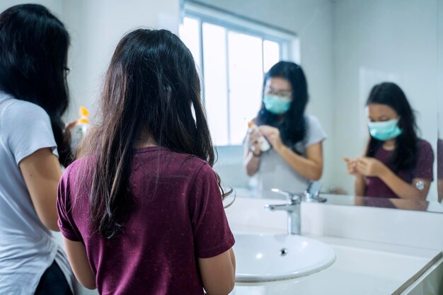 Moeder en haar kind handen wassen met zeep