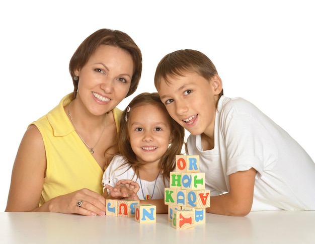 Moeder en haar kinderen spelen met kubussen geïsoleerd op wit