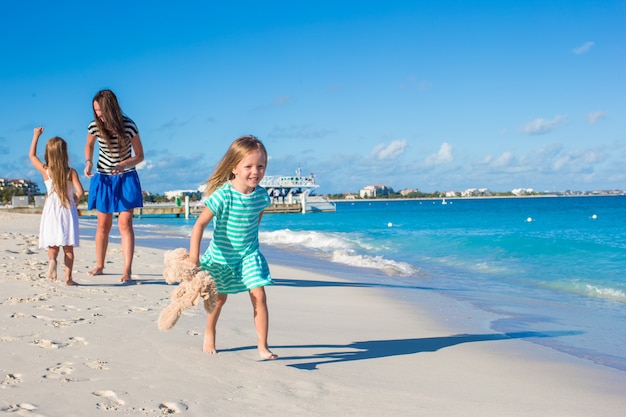 Moeder en haar kleine dochters plezier op exotische strand op zonnige dag