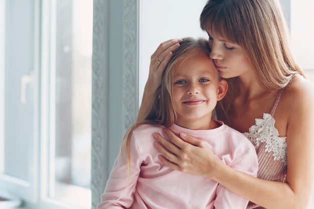 Moeder en haar kleine lopende dochter knuffelen en glimlachen