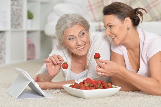 Moeder en haar volwassen dochter die verse aardbeien eten