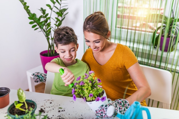 Moeder en jongen kind samen planten van de planten