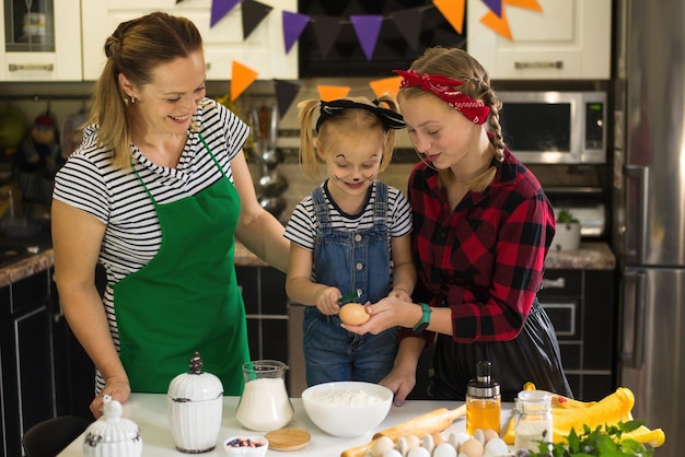 Foto moeder en kind bereiden feestelijk eten voor halloween en verjaardag