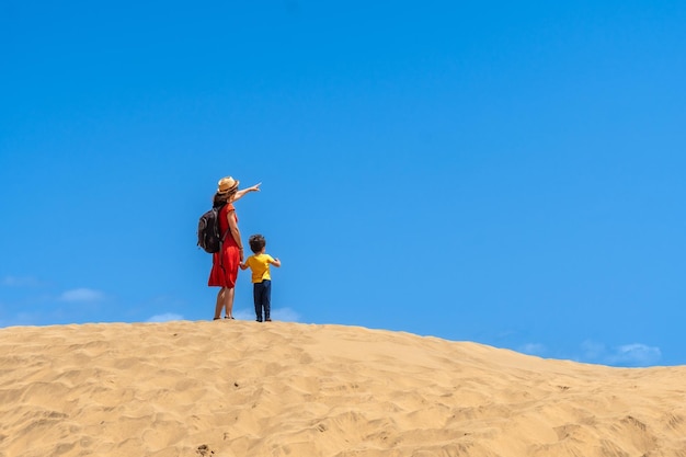 Moeder en kind glimlachen in de duinen van Maspalomas in de zomer Gran Canaria Canarische eilanden