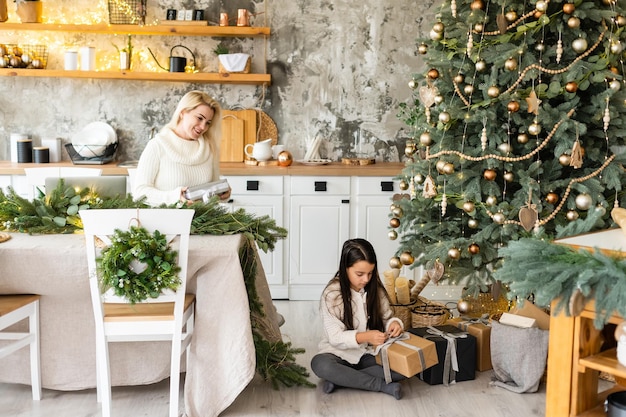 Moeder en kind knuffel voor een kerstboom.