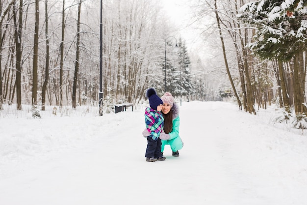 Moeder en kind meisje op een winterwandeling in de natuur. Gelukkig gezin.