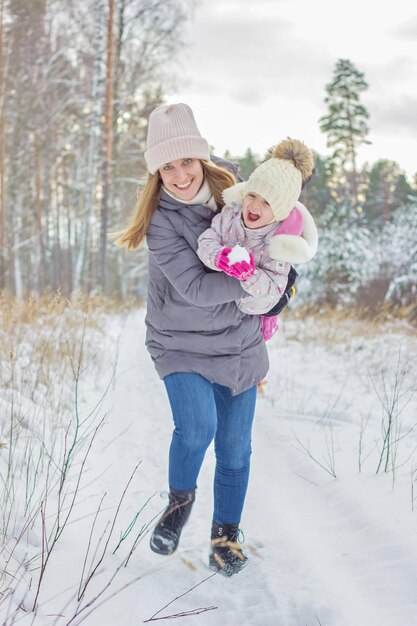 Moeder en kind meisje op een winterwandeling in de natuur