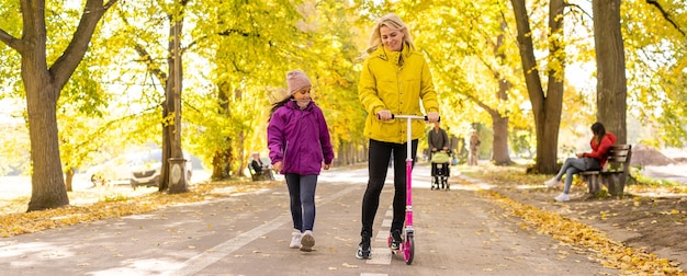 Moeder en kind met een scooter op straat,