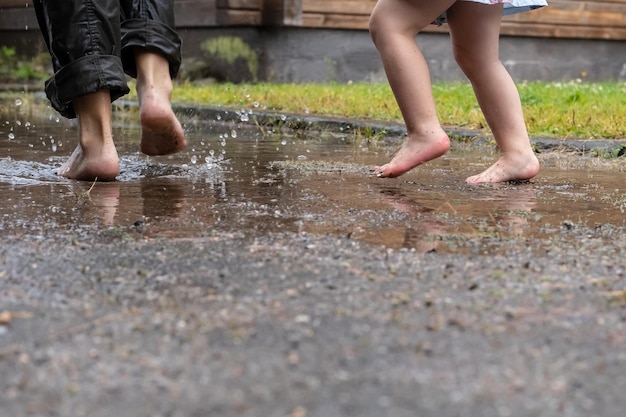 Moeder en kind rennen lekker door de plassen na de regen