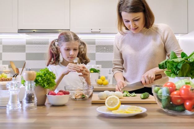 Moeder en kind samen koken thuis in de keuken