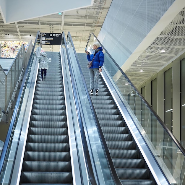 Moeder en kind samen op roltrap achtergrond Terminal luchthaven reizen liefdeszorg