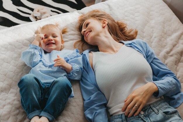 Moeder en kind spelen en hebben plezier op het bed. Moederdag.